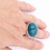 Bijou artisanal en céramique couleur bleu canard sur une main